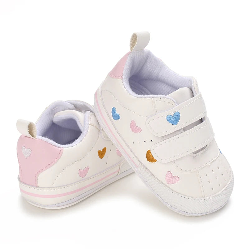 Baby girl soft sole crib shoes by Baby Bubble, first walker style, featuring pink and white design with adorable bow accents.