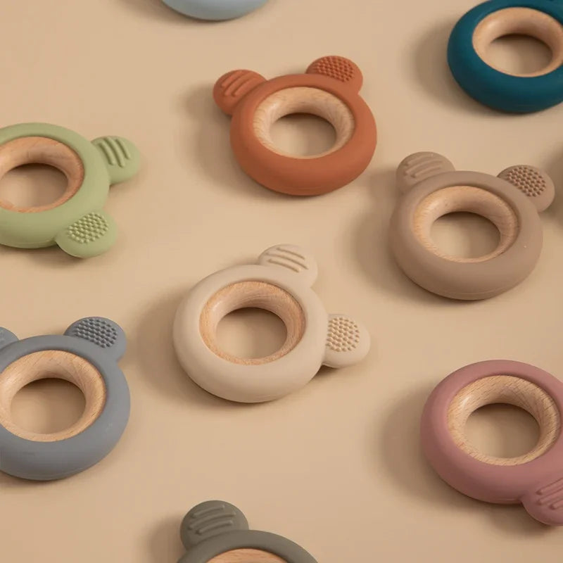 Baby Bubble silicone wood teether ring, safe soothing chew toy with natural wood and soft silicone for babies, shown in close-up.