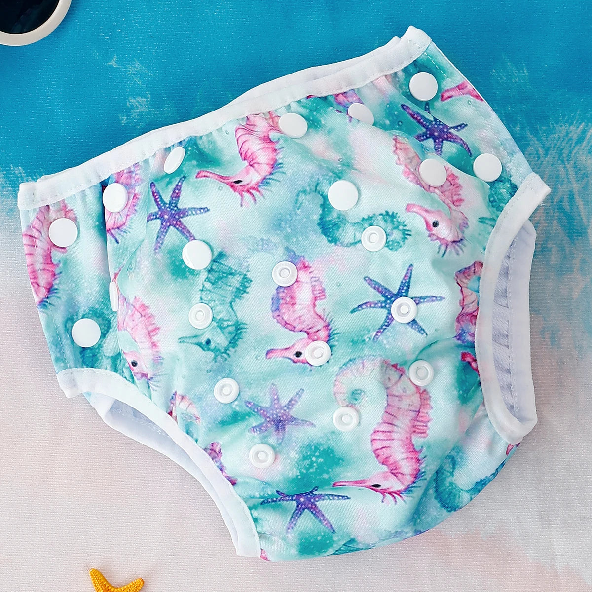 Baby Bubble reusable swim diapers with colorful animal print design, perfect for infants during pool or beach time.