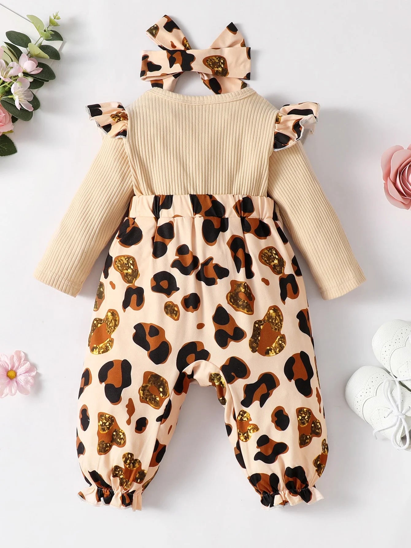 Baby girl wearing a leopard print jumpsuit set with ruffle trim and matching headband by Baby Bubble.